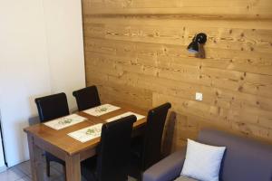 a dining room with a wooden table and chairs at Joli T2 + coin montagne + Garage in Briançon