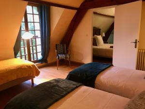 a hotel room with two beds and a mirror at Domaine de Joreau in Gennes