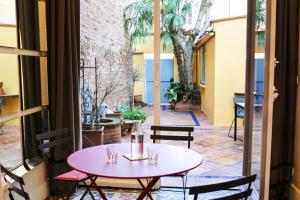a pink table and chairs on a patio at TOULOUSAINE DE STANDING - GARAGE - COUR - CINEMA in Toulouse