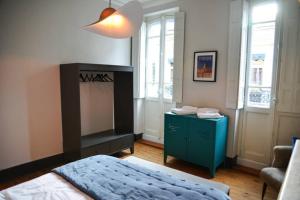 a bedroom with a bed and a blue cabinet and windows at TOULOUSAINE DE STANDING - GARAGE - COUR - CINEMA in Toulouse