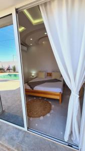 um quarto com uma cama e uma janela com vista em Villa Lina Moderne toute équipée & Piscine em Midoun