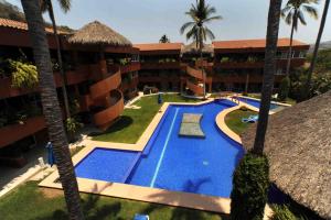 an aerial view of a hotel with a swimming pool and palm trees at La Ceiba del Mar in Zihuatanejo