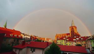 un arco iris en el cielo sobre una ciudad con edificios en Apartament CCH - Biskupia, en Chełmno