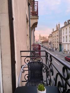 a balcony with a table and chair on a city street at chez Muriel,T2 de charme, parc Ste Marie, Nancy Thermal, Mon Désert in Nancy