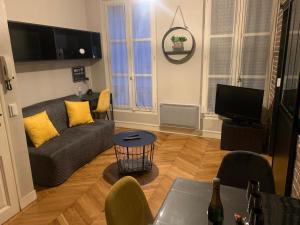 a living room with a couch and a tv at Appartement centre Fontainebleau in Fontainebleau