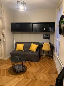 a living room with a couch and a table at Appartement centre Fontainebleau in Fontainebleau