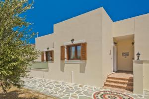 a white house with stairs and a tree at Olive Studios Karpathos Studio #4 in Karpathos