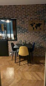 Appartement centre Fontainebleau في فونتينبلو: طاولة وكراسي أمام جدار من الطوب