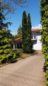 a house with two trees in front of a driveway at Megtart-lak Villa in Balatonszárszó