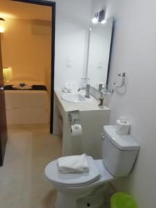 a bathroom with a toilet and a sink and a mirror at Kin Ha Tulum Hotel in Tulum