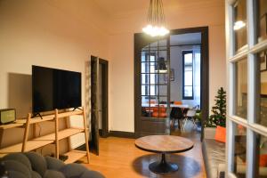 a living room with a tv and a couch and a table at TOULOUSAINE DE STANDING - GARAGE - COUR - CINEMA in Toulouse