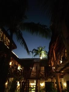 a night view of a resort with a palm tree at Kin Ha Tulum Hotel in Tulum