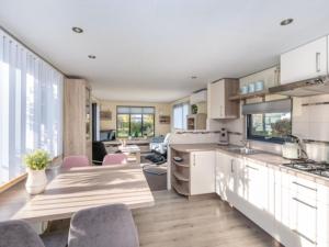 a kitchen and living room with a table and chairs at Chalet Sea Rocks with view and garden in Goedereede