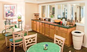 アーリントンハイツにあるDays Inn & Suites by Wyndham Arlington Heightsのキッチン(カウンター、テーブル、椅子付)