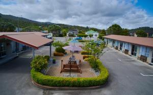 an empty parking lot with a picnic table and umbrella at Aachen Place Motel in Greymouth