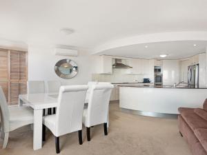 a kitchen and dining room with a white table and chairs at Le Point 702 Luxury and Views in Forster