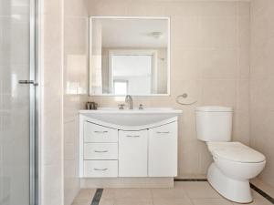a bathroom with a toilet and a sink and a mirror at Le Point 702 Luxury and Views in Forster