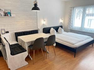 um quarto com uma cama, uma mesa e cadeiras em Zentrale gemütliche Wohnung St Moritz - A212 em St. Moritz