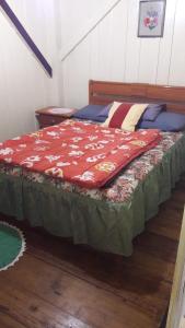 a bed with a red blanket on top of it at Sítio para Famílias em Pomerode - Santa Catarina in Pomerode