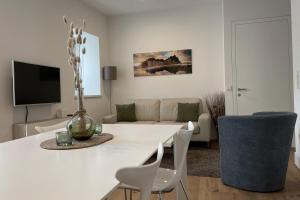 un soggiorno bianco con tavolo e sedie bianchi di Apartments Griesser a Bressanone