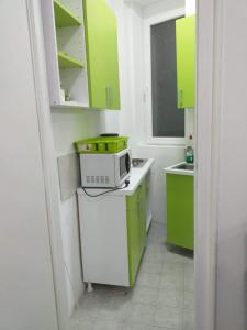 une petite cuisine avec des armoires vertes et un four micro-ondes dans l'établissement Belvedere Skadarska Apartment, à Belgrade
