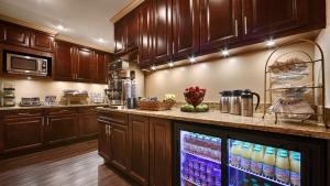 a kitchen with wooden cabinets and a counter with a refrigerator at Best Western Plus Hawthorne Terrace Hotel in Chicago