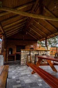 un patio con mesas de picnic de madera y una chimenea de piedra. en Cabañas Abigail en Nono