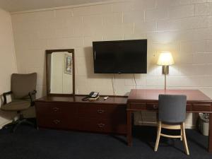 a room with a desk and a television on a wall at Childress Inn in Childress