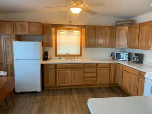 a kitchen with wooden cabinets and a white refrigerator at Mississippi River Cabin in Bellevue +9 photos