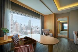 a living room filled with furniture and a large window at Amari Watergate Bangkok - SHA Extra Plus Certified in Bangkok