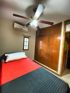 1 dormitorio con 1 cama y ventilador de techo en La Casa de Los Sueños en San Juan