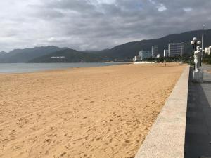 a sandy beach with a view of the ocean and buildings at Hoàng Hưng Hotel in Quy Nhon
