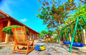a playground with chairs and a swing set at Cat Tien Backpackers Hostel in Cat Tien