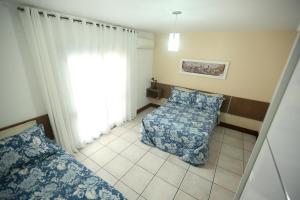 a bedroom with a bed and a window at Chalé Rosé in Torres