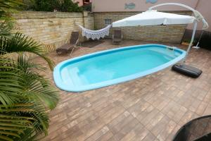 a hot tub on a patio with an umbrella at Chalé Rosé in Torres