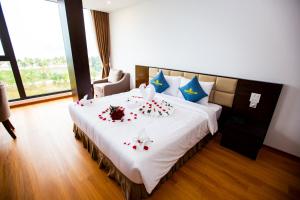 下龍灣的住宿－Golden Palm HaLong Hotel，一间卧室配有一张带鲜花的大床