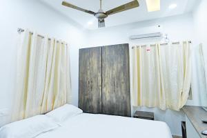 una camera da letto con un letto e un ventilatore a soffitto di R Square Guest inn a Nellore