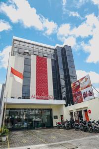 a building with motorcycles parked in a parking lot at Alam Hotel by Cordela in Medan