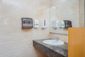 a bathroom with a sink and a mirror at Alam Hotel by Cordela in Medan +24 photos