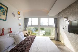 a bedroom with a large bed and a large window at 阜東樓 in Tainan
