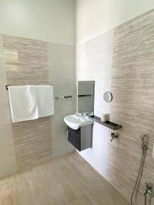 a bathroom with a sink and a mirror at CoLiving CHE Beach House by Vale Pine in Kuala Terengganu