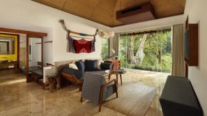 a living room filled with furniture and a window at Maya Ubud Resort & Spa in Ubud
