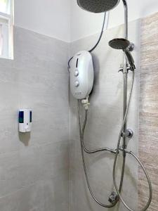 a shower with a shower head in a bathroom at CoLiving CHE Beach House by Vale Pine in Kuala Terengganu