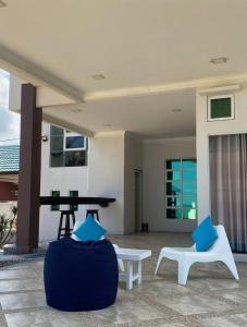 a patio with a ping pong table and two chairs at CoLiving CHE Beach House by Vale Pine in Kuala Terengganu