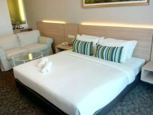 a hotel room with two beds and two lamps at The Inn in Bintulu