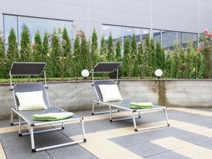 two chairs sitting on a patio in front of a building at Gorgeous Apartment in Markdorf with Swimming Pool in Markdorf