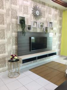 a living room with a flat screen tv on a wall at D Wangi Homestay Pasir Gudang at Ecotropic in Pasir Gudang