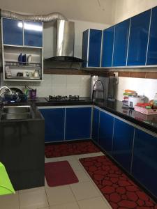 een keuken met blauwe kasten en een wastafel bij D Wangi Homestay Pasir Gudang at Ecotropic in Pasir Gudang