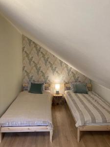 twee bedden in een kamer met een muur bij Brezno Apartament in Gdańsk