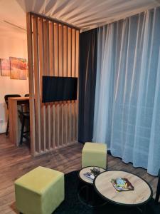 ein Wohnzimmer mit 2 Stühlen, einem Tisch und einem TV in der Unterkunft Studio Djurdja in Divčibare